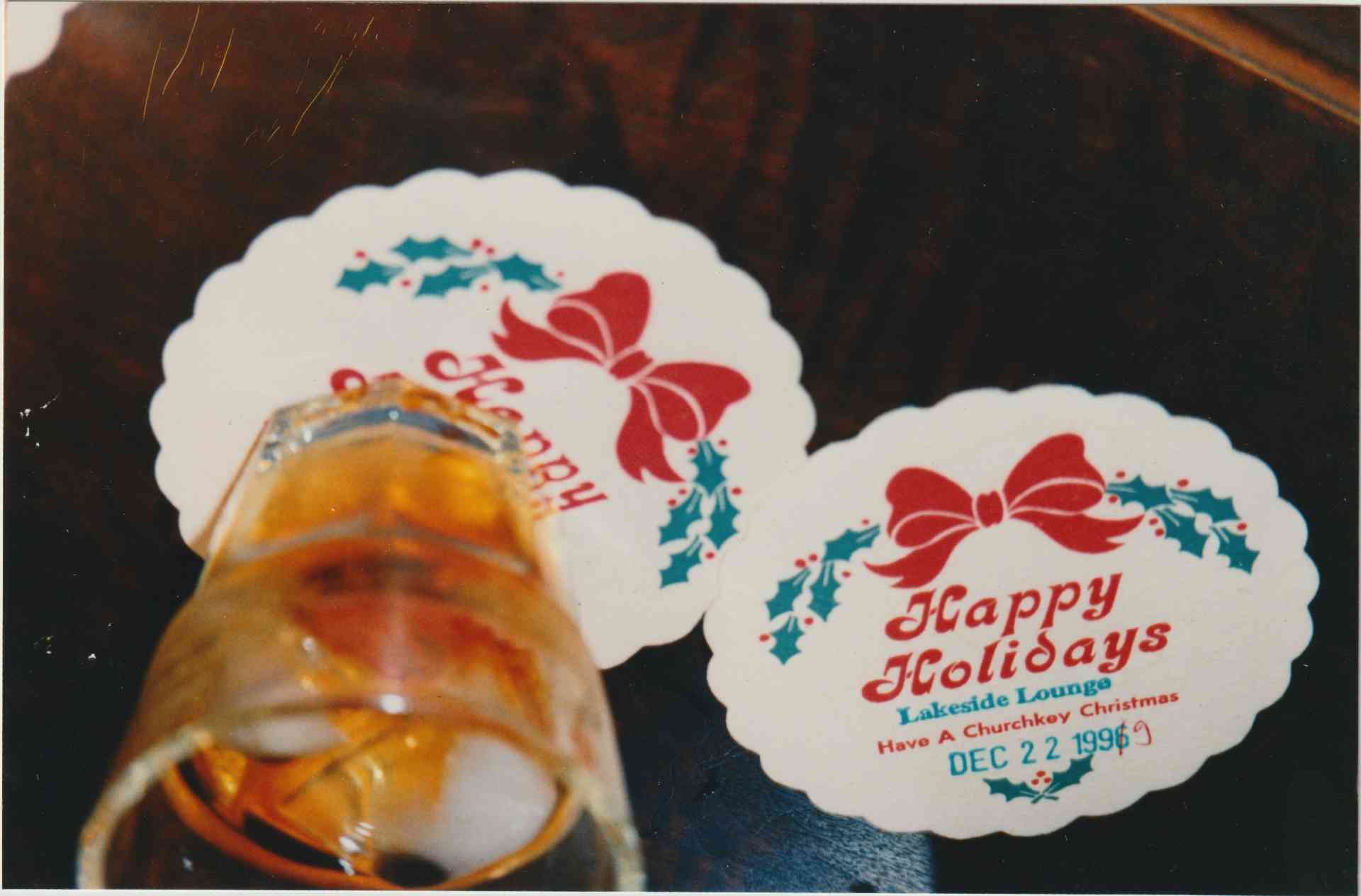 a glass of booze on a holiday coaster