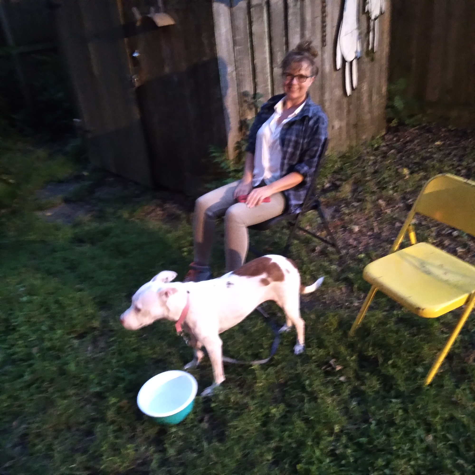 Gina Phillips and Daisy the dog at a bonfire, Tricou Stret, New Orleans, September 27, 2021.